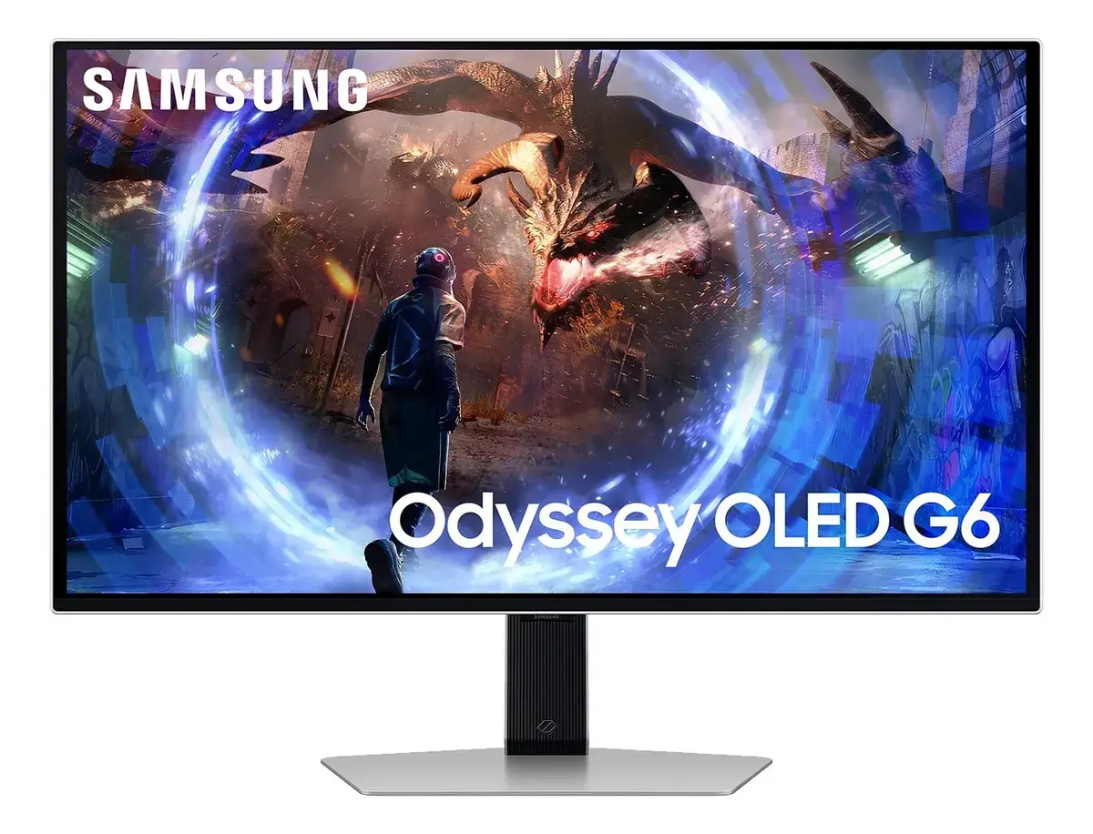 Monitor Samsung Odyssey OLED G6 de marco plateado, con un personaje de espaldas frente a un dragón en un portal azul en la pantalla, el logo Samsung y el texto Odyssey OLED G6; pie de columna plateado